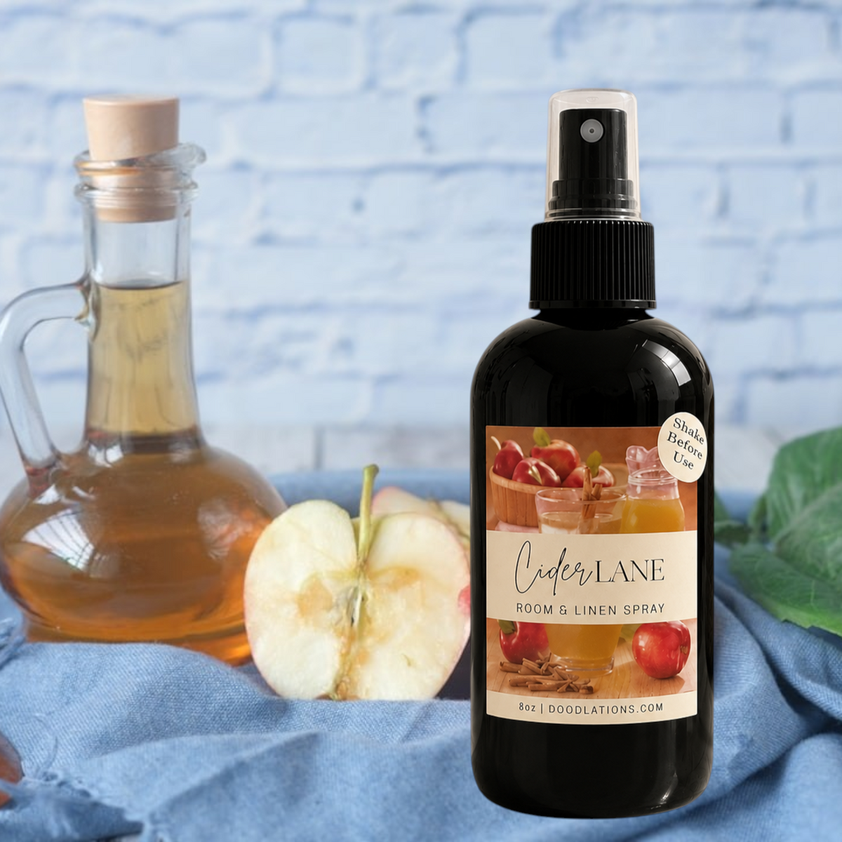 Doodlations Coffee Bar & Boutique Cider Lane room and linen spray in a black bottle with apple and cinnamon imagery.