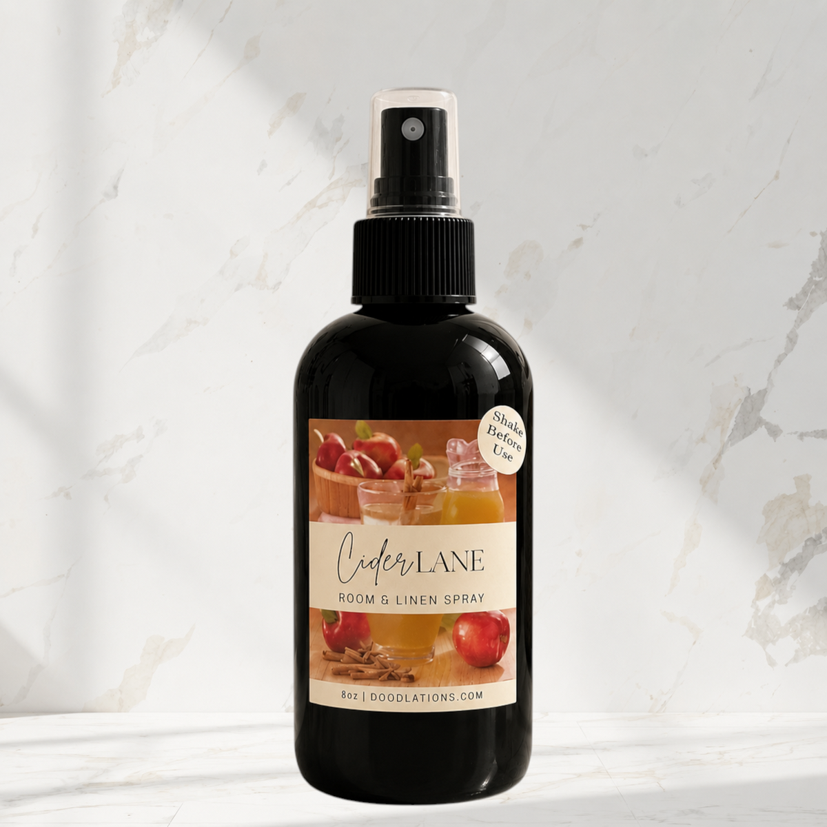 Doodlations Coffee Bar & Boutique Cider Lane room and linen spray in a black bottle with an apple and spice label.