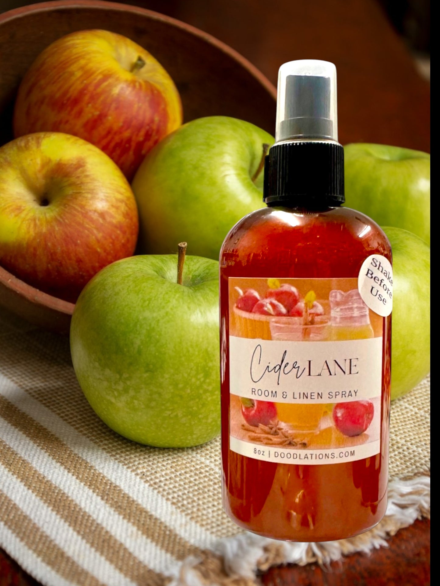 Doodlations Coffee Bar & Boutique Cider Lane Room & Linen Spray with apples and cinnamon sticks. 8oz bottle.