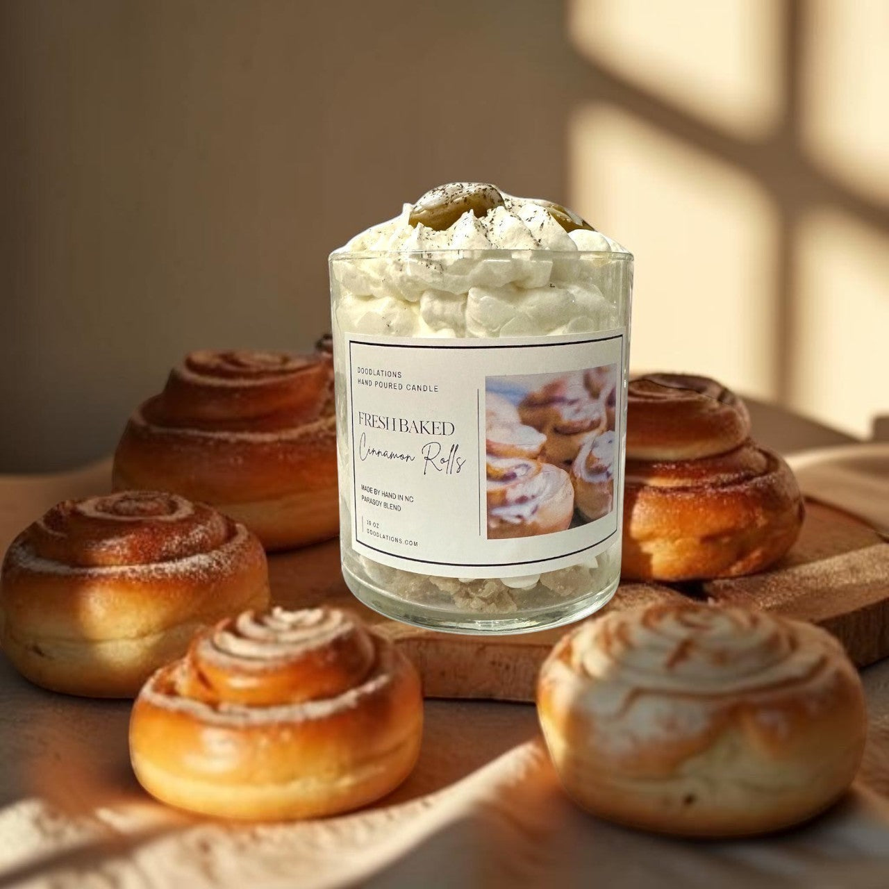 Doodlations Coffee Bar & Boutique Cinnamon Bun candle with decorative wax toppings resembling cinnamon rolls and whipped cream.