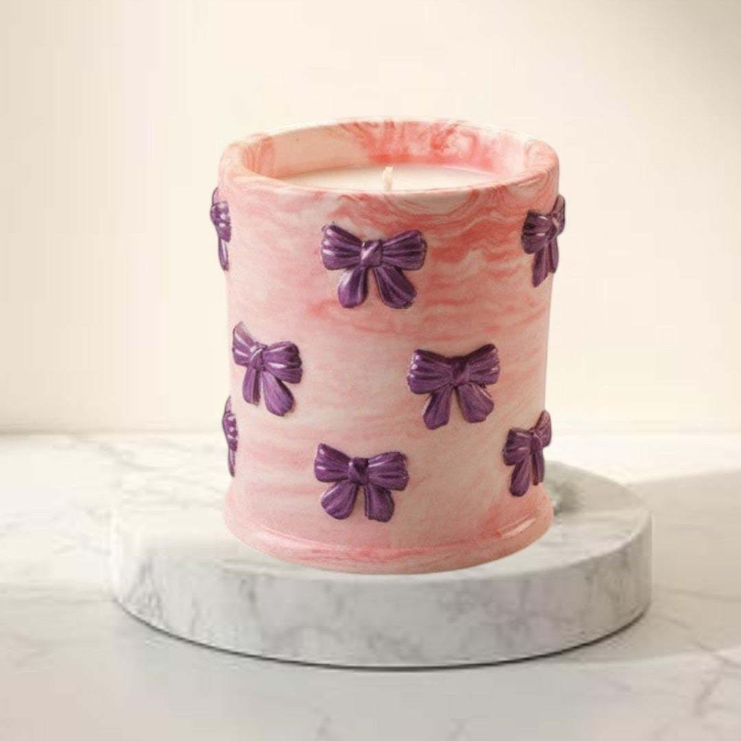 Doodlations Coffee Bar & Boutique pink marbled concrete candle with purple bow accents, soy blend wax, Tipsy Berry Cherry scent.