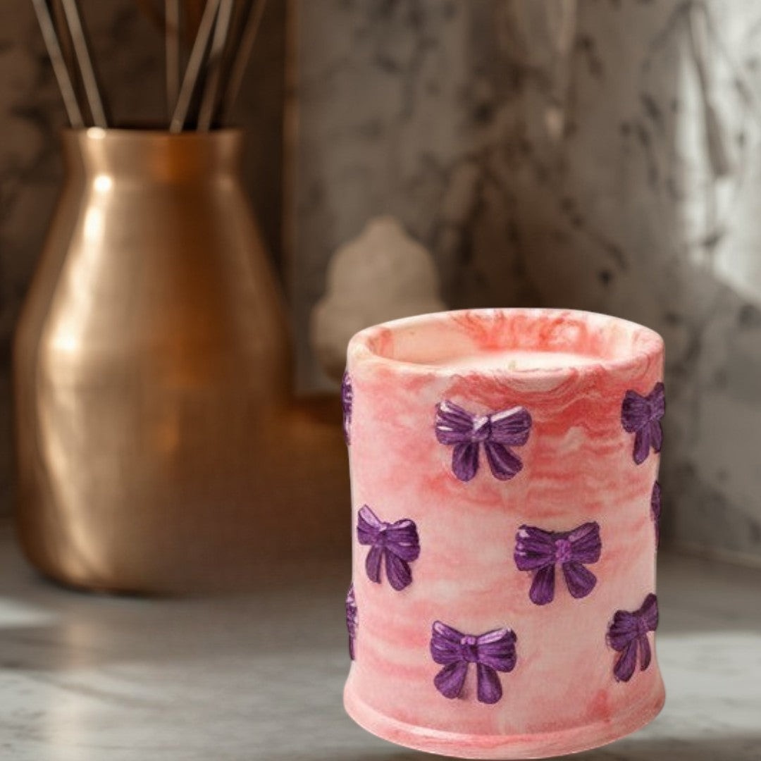 Doodlations Coffee Bar & Boutique pink marbled concrete candle with purple bow accents, soy blend wax, Tipsy Berry Cherry scent.