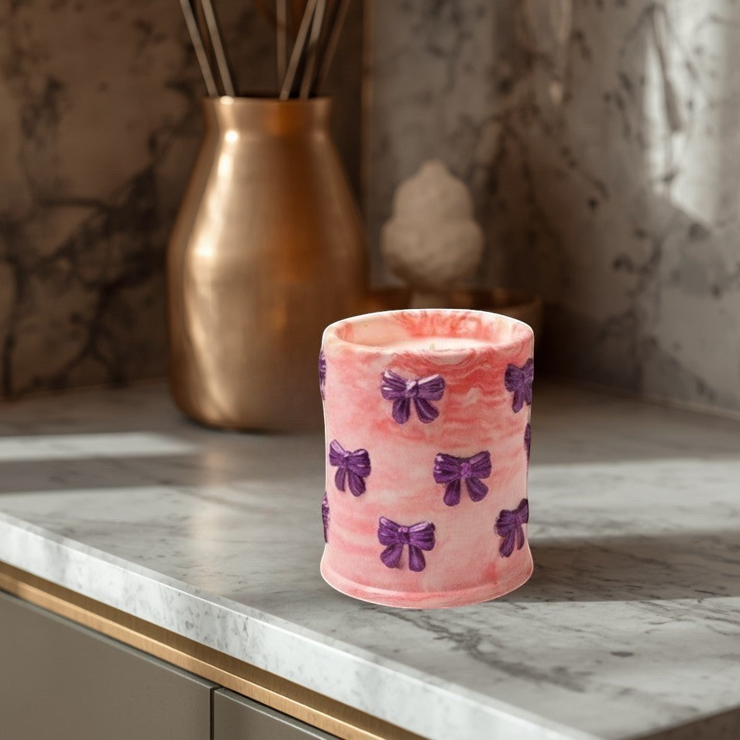 Doodlations Coffee Bar & Boutique pink marbled concrete candle with purple bow accents, soy blend wax, Tipsy Berry Cherry scent.