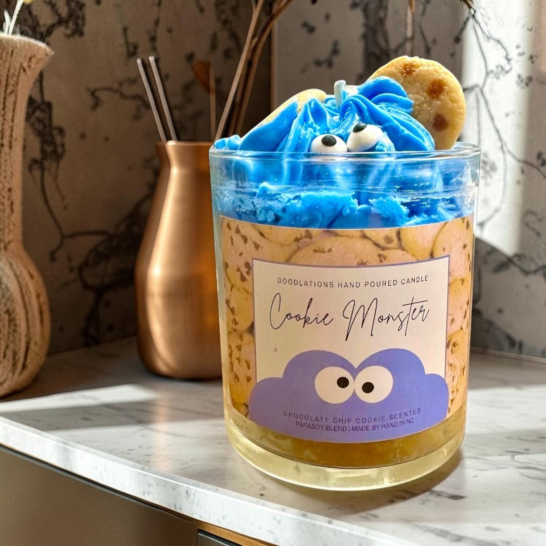 Doodlations Coffee Bar & Boutique Cookie Monster candle with blue frosting, googly eyes, and cookie accents. Chocolate chip cookie scent.
