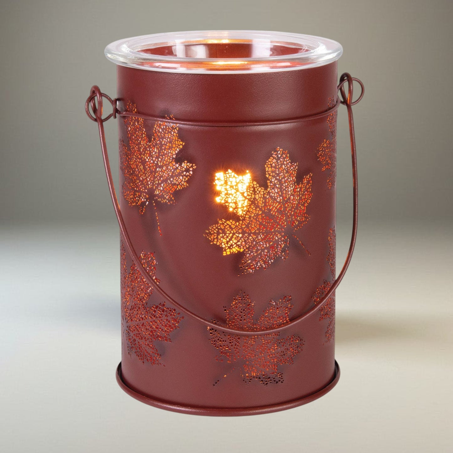 Doodlations Coffee Bar & Boutique antique-brushed copper wax warmer with cut-out fall leaf patterns and glass dish.