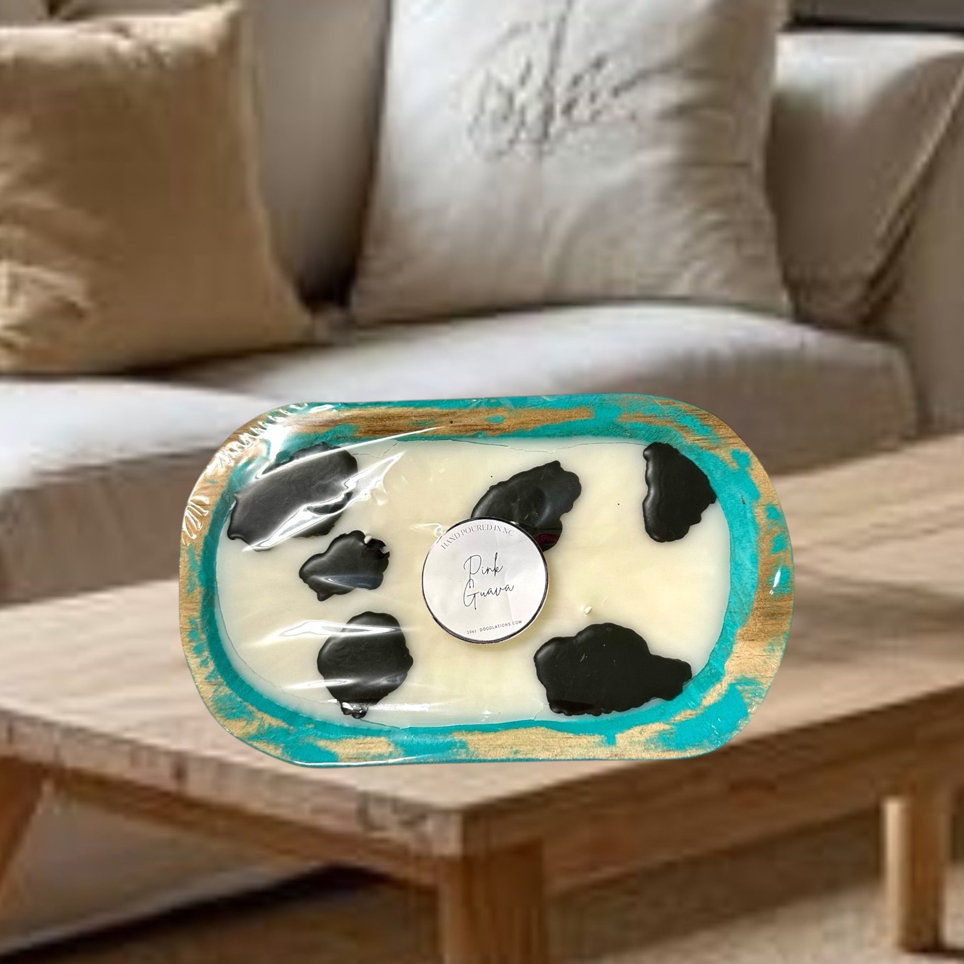 Doodlations Coffee Bar & Boutique cow dough bowl candle in pink guava scent, with black cow spots.