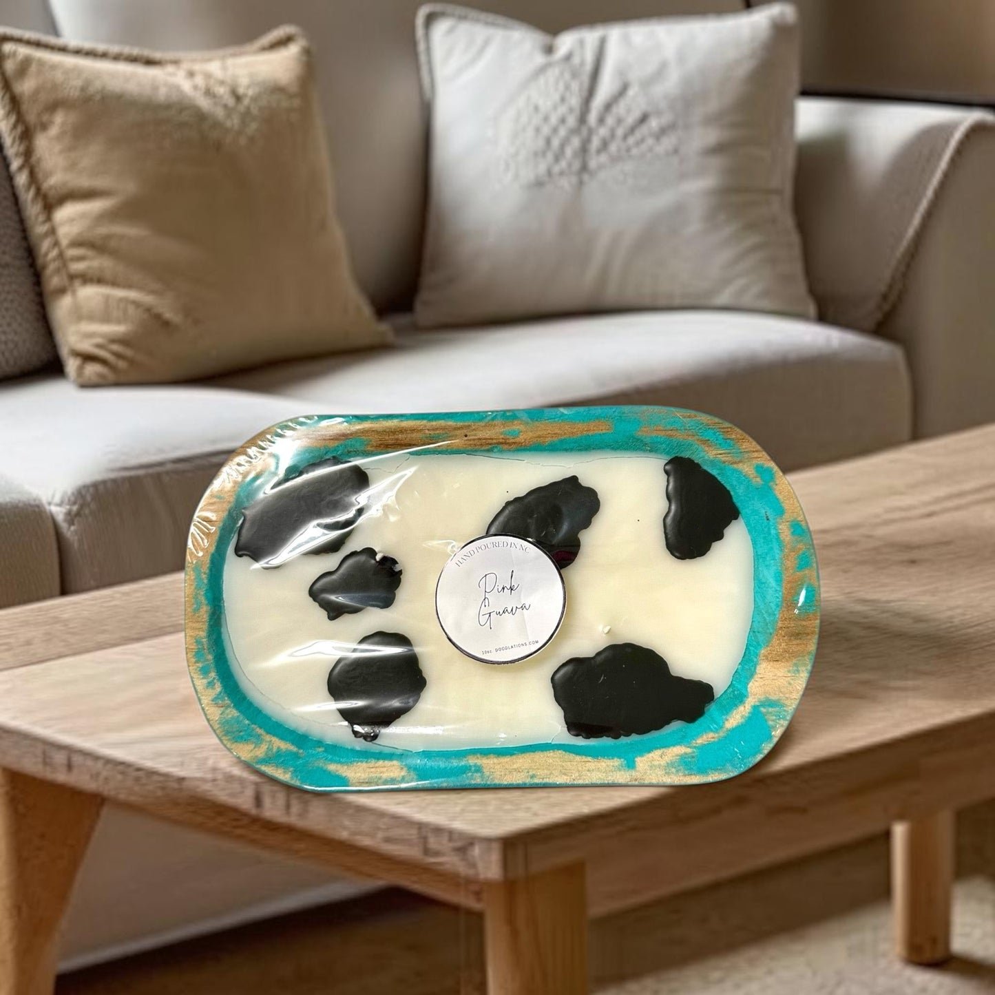 Doodlations Coffee Bar & Boutique cow dough bowl candle in pink guava scent, with black cow spots.