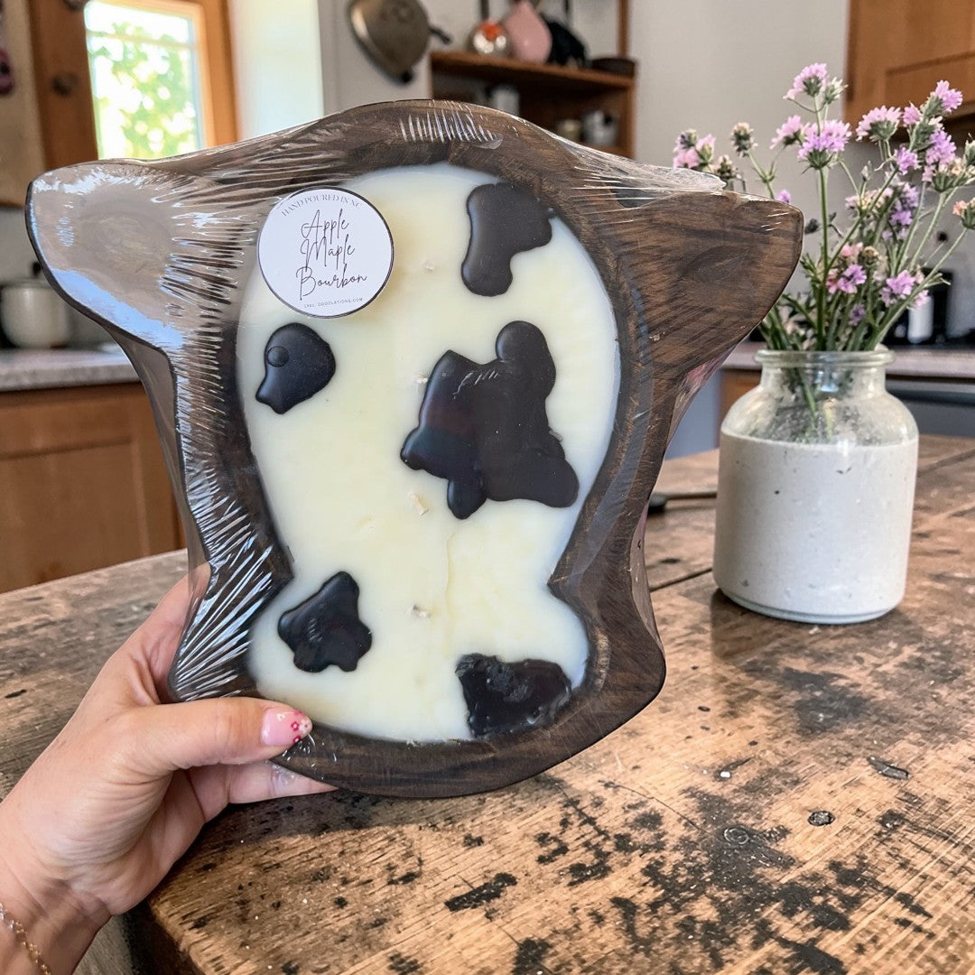 Doodlations Coffee Bar & Boutique Apple Maple Bourbon large cow head wooden dough bowl candle with black spots.