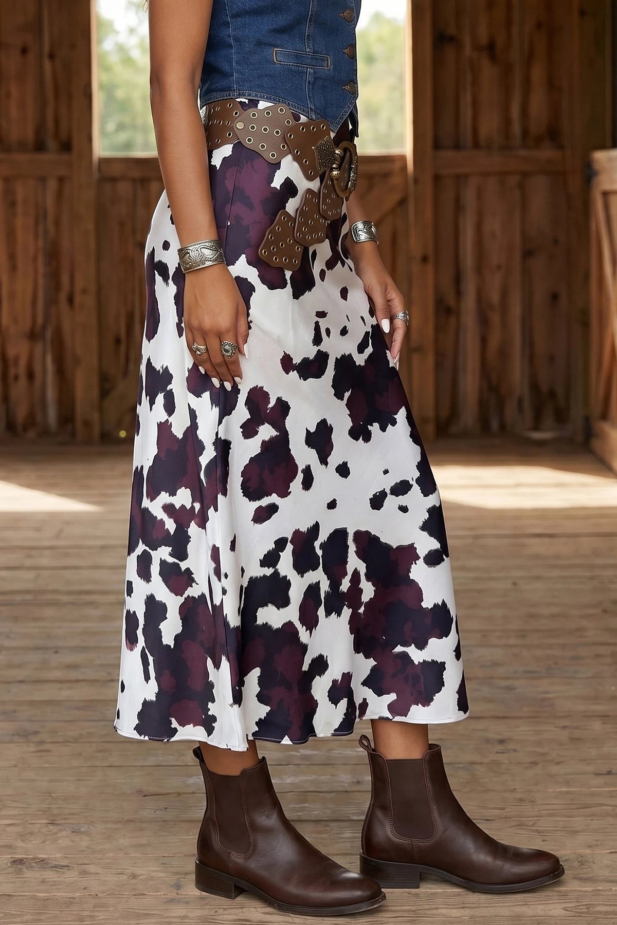 Doodlations Coffee Bar & Boutique brown and white abstract cow print midi skirt with a wide studded western belt.