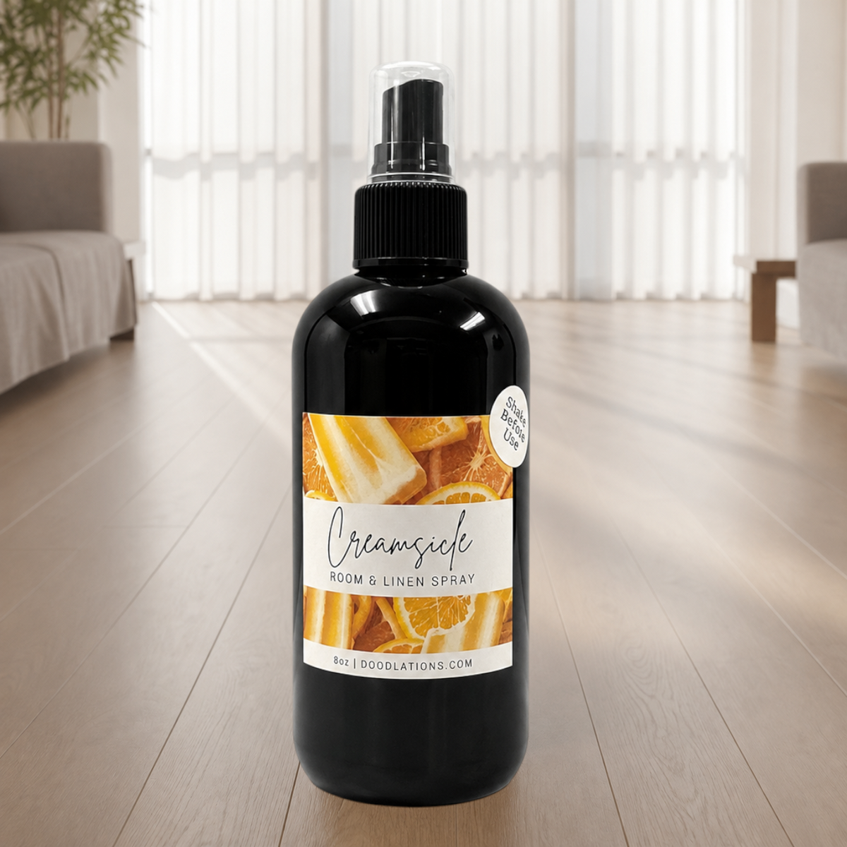 Doodlations Coffee Bar & Boutique Creamsicle room and linen spray in a black bottle with citrus fruit label design.