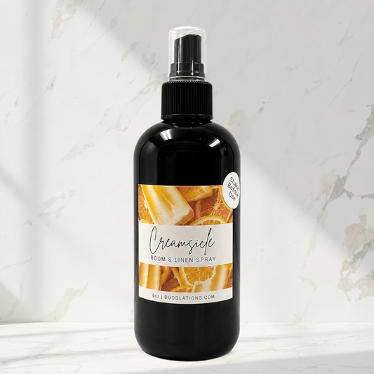 Doodlations Coffee Bar & Boutique Creamsicle room and linen spray in a black bottle with citrus fruit label design.