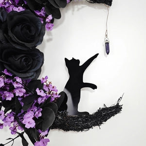 Doodlations Coffee Bar & Boutique crescent moon wreath with black roses, purple flowers, cat silhouette, and crystal.
