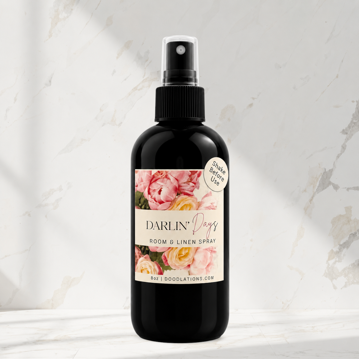 Doodlations Coffee Bar & Boutique Darlin’ Days room and linen spray in a black bottle with floral label on marble