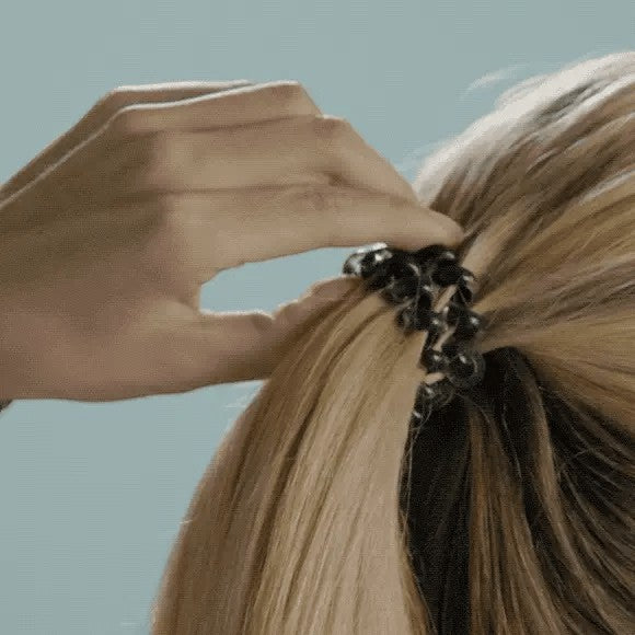 Doodlations Coffee Bar & Boutique washed denim hair tie securing a blonde ponytail with a strong, damage-free grip.