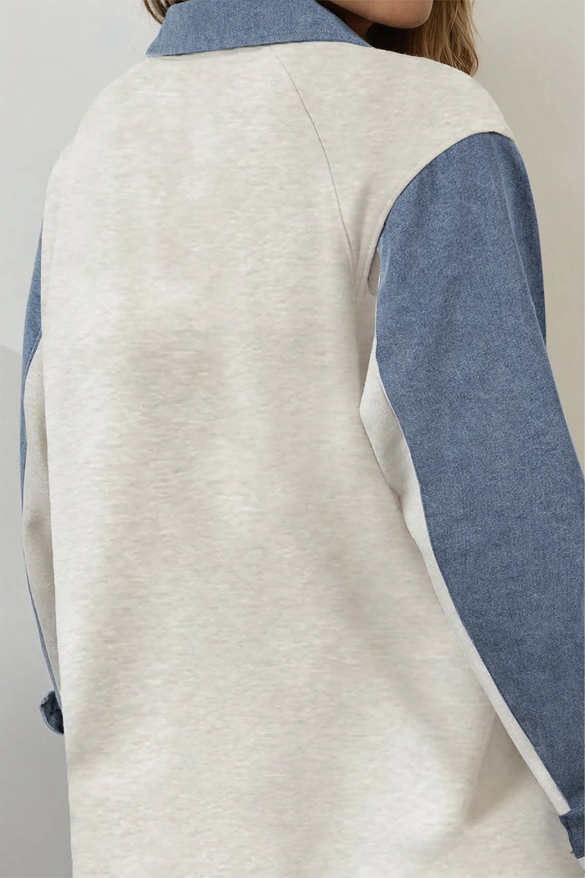 Doodlations Coffee Bar & Boutique light grey and blue denim patchwork long sleeve top with a polo collar, back view.