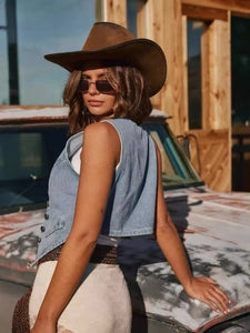 Doodlations Coffee Bar & Boutique cropped blue denim vest worn by a woman in a brown cowboy hat and sunglasses
