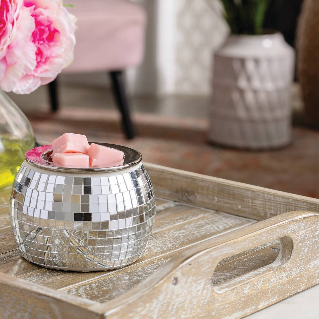 Doodlations Coffee Bar & Boutique silver disco ball wax warmer with pink wax melts on a wooden tray.