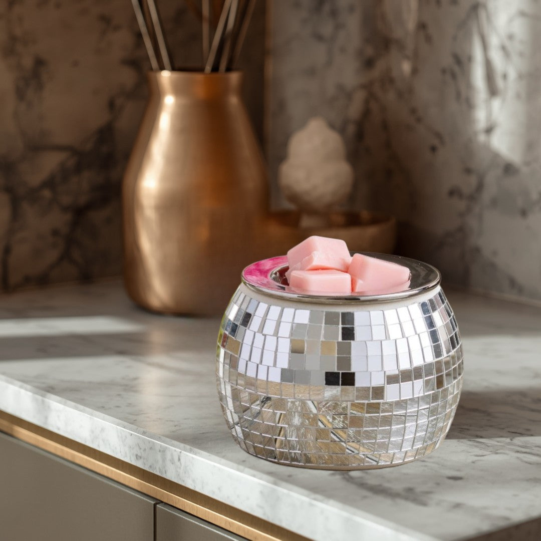 Doodlations Coffee Bar & Boutique silver disco ball wax warmer with pink wax melts on a wooden tray.