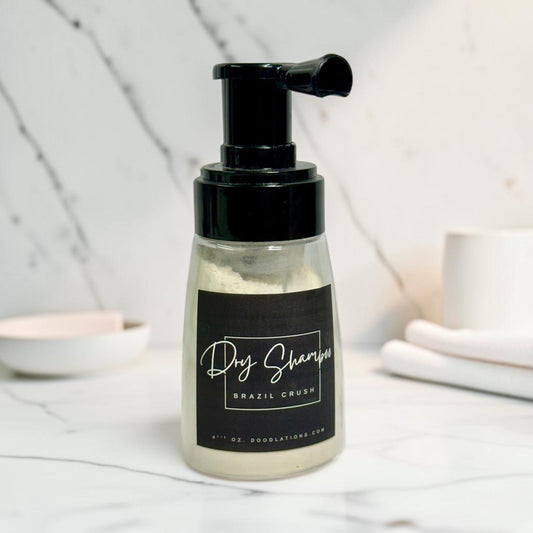 Doodlations Coffee Bar & Boutique dry powder shampoo in a clear pump bottle with a black label on marble background.