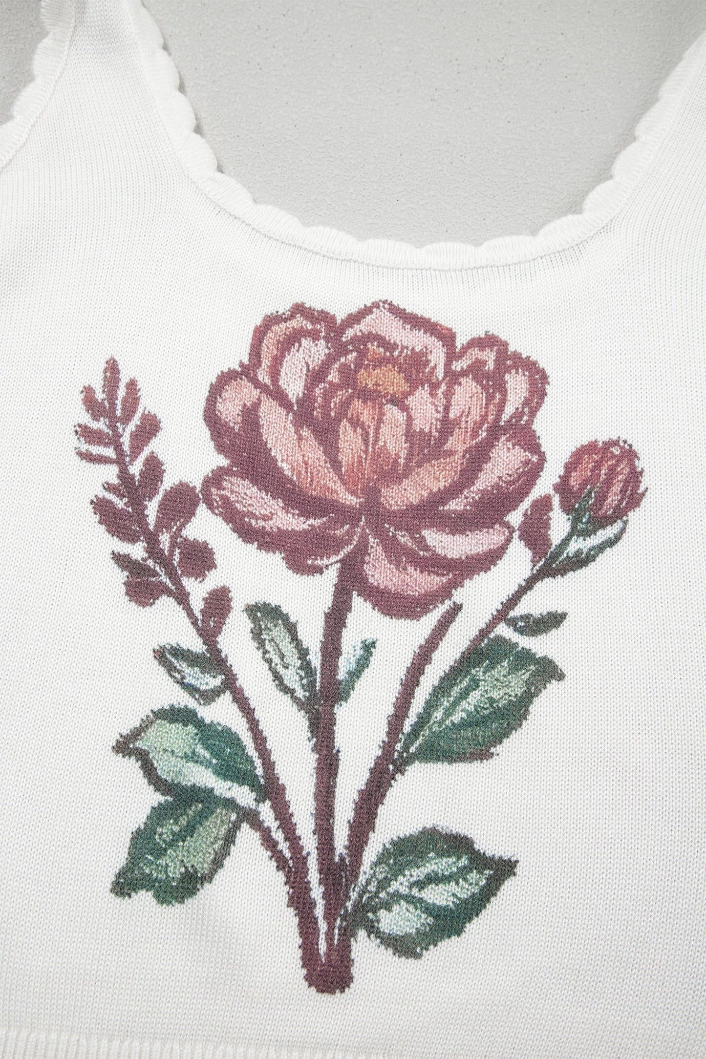 Doodlations Coffee Bar & Boutique white knit tank top featuring a detailed pink floral graphic and scalloped neckline.