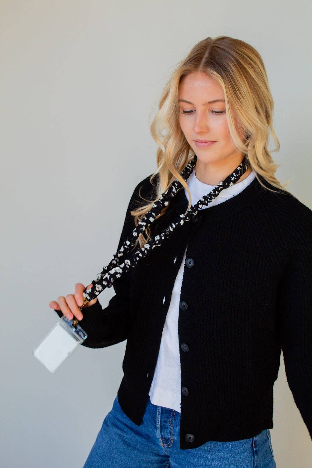 Doodlations Coffee Bar & Boutique black and white floral polyester lanyard worn by a woman in a black cardigan
