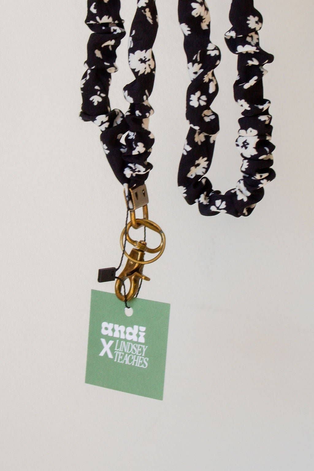 Doodlations Coffee Bar & Boutique black and white floral polyester lanyard with a gold-tone metal clasp