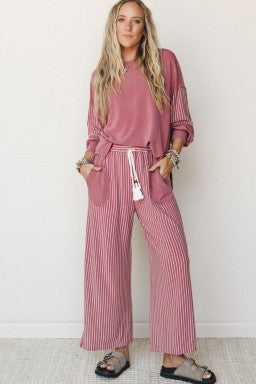 Model wearing a Doodlations Coffee Bar & Boutique fuchsia patchwork long sleeve top and striped wide-leg pants set