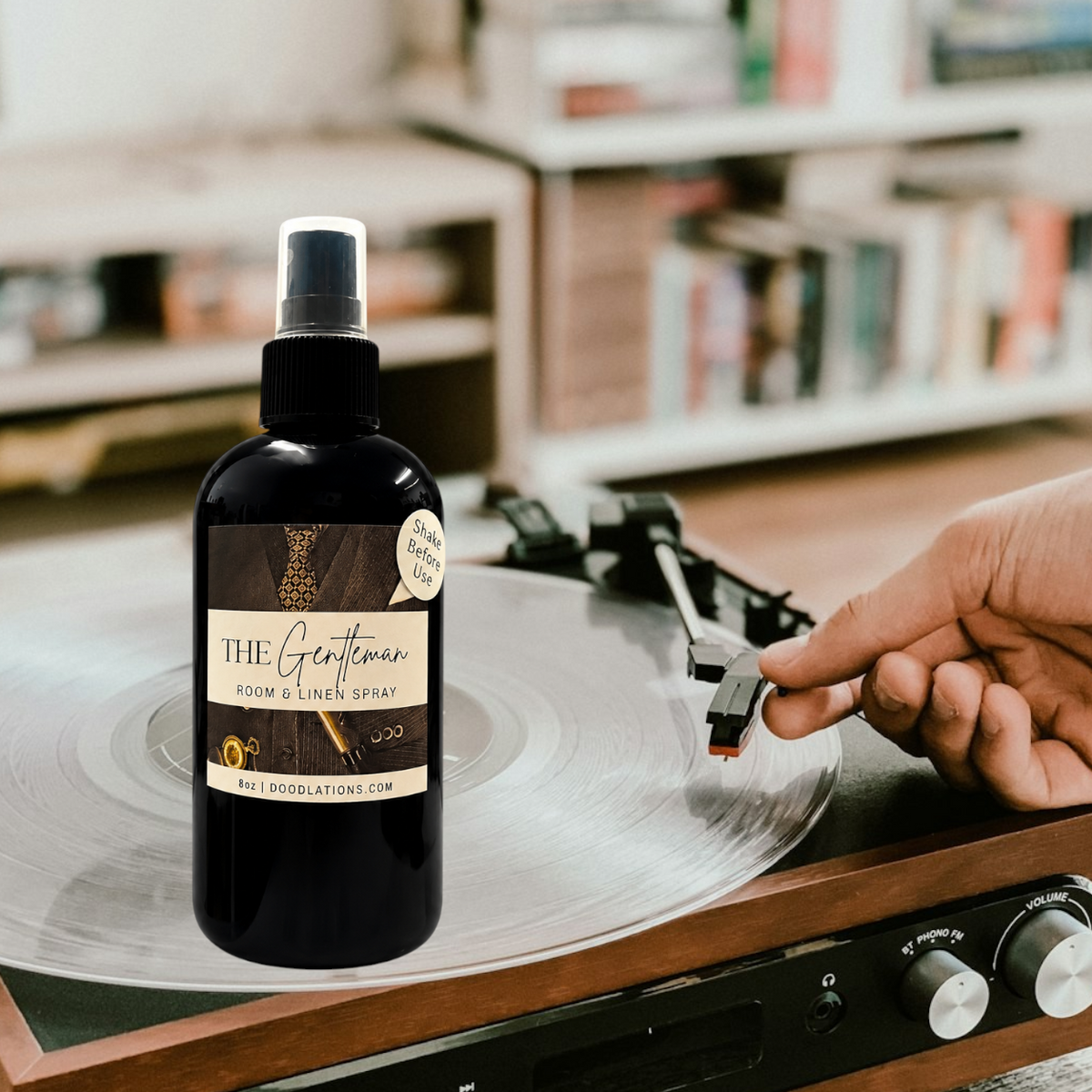 Doodlations Coffee Bar & Boutique The Gentleman room and linen spray in a black bottle next to a vinyl record player.