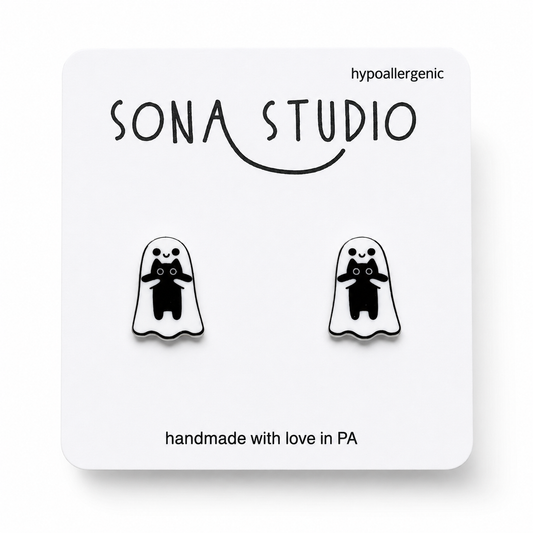 Doodlations Coffee Bar & Boutique handmade acrylic stud earrings featuring a cute white ghost holding a black cat.