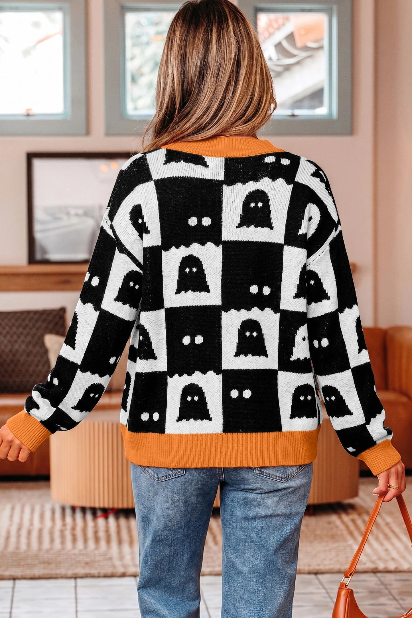 Doodlations Coffee Bar & Boutique black and white geometric ghost print knit cardigan with orange trim and drop shoulders