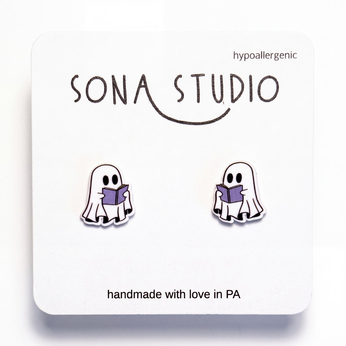 Doodlations Coffee Bar & Boutique handmade ghost earrings featuring a cute ghost reading a purple book on titanium posts