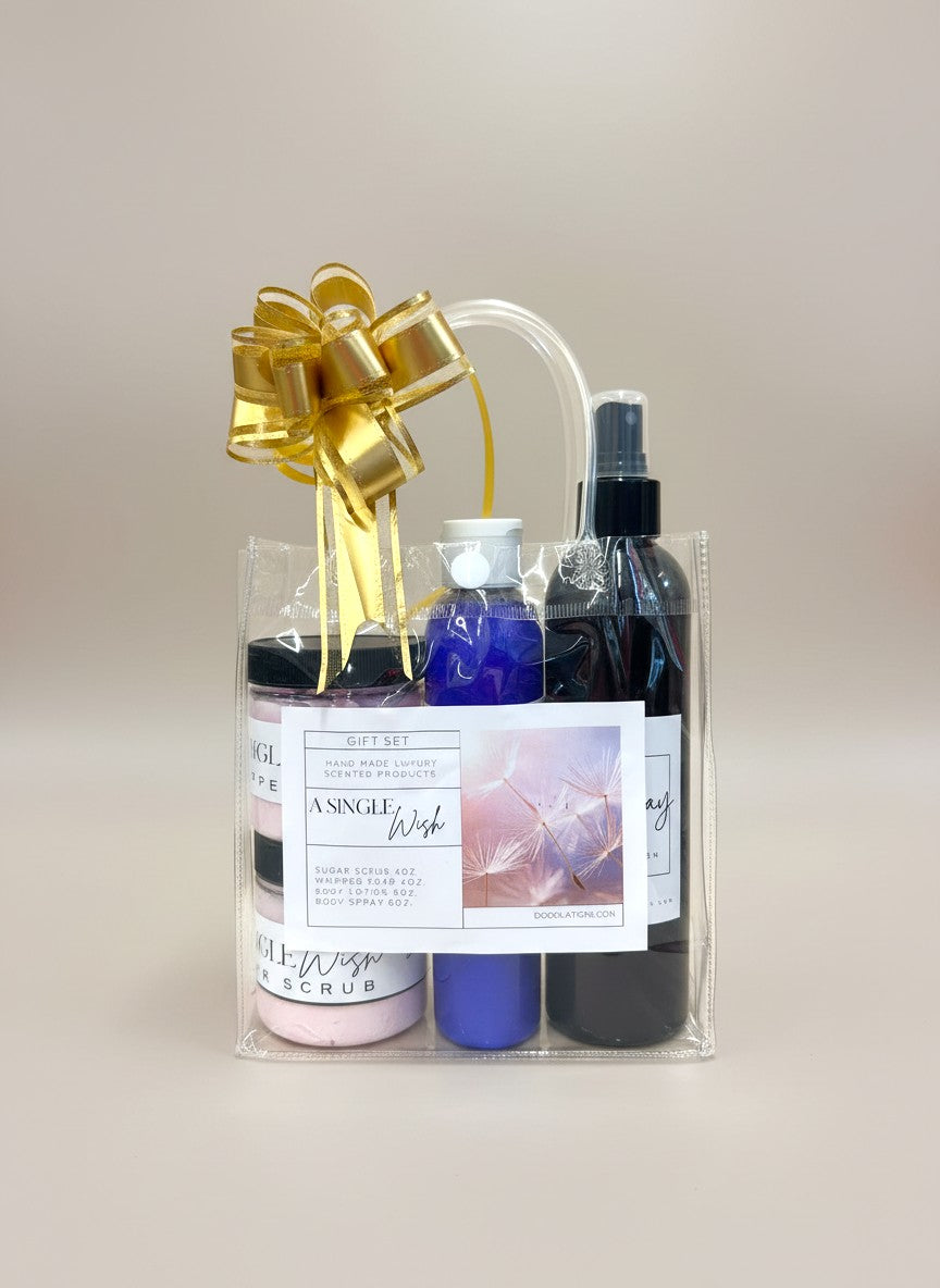 Doodlations Coffee Bar & Boutique gift set with sugar scrub, whipped soap, body lotion, and body spray in a clear bag with a gold bow.