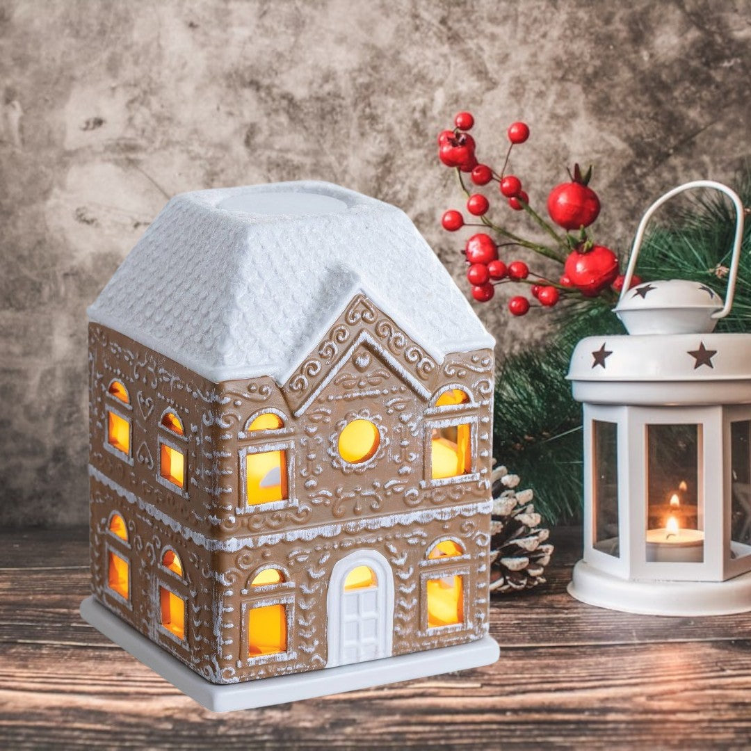 Doodlations Coffee Bar & Boutique Gingerbread House Fragrance Warmer with white roof and illuminated windows.