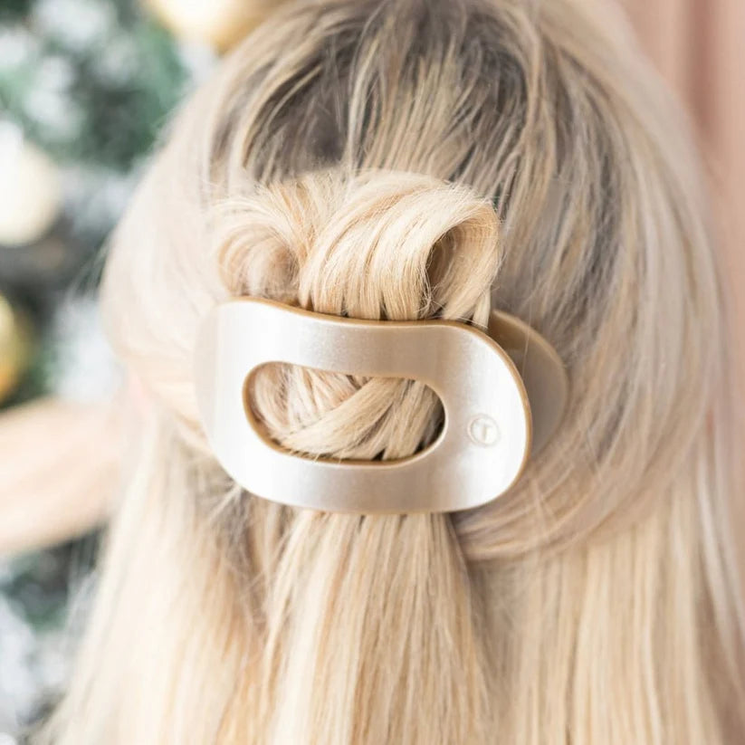 Doodlations Coffee Bar & Boutique gold flat round hair clip worn in blonde hair for a secure, comfortable hold.