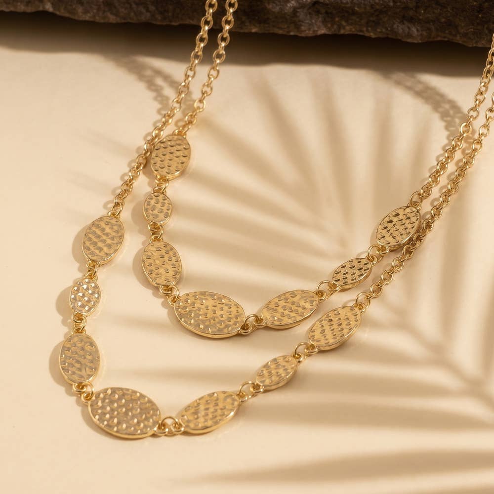 Doodlations Coffee Bar & Boutique gold-tone layered necklace with hammered oval stations and delicate chain links.