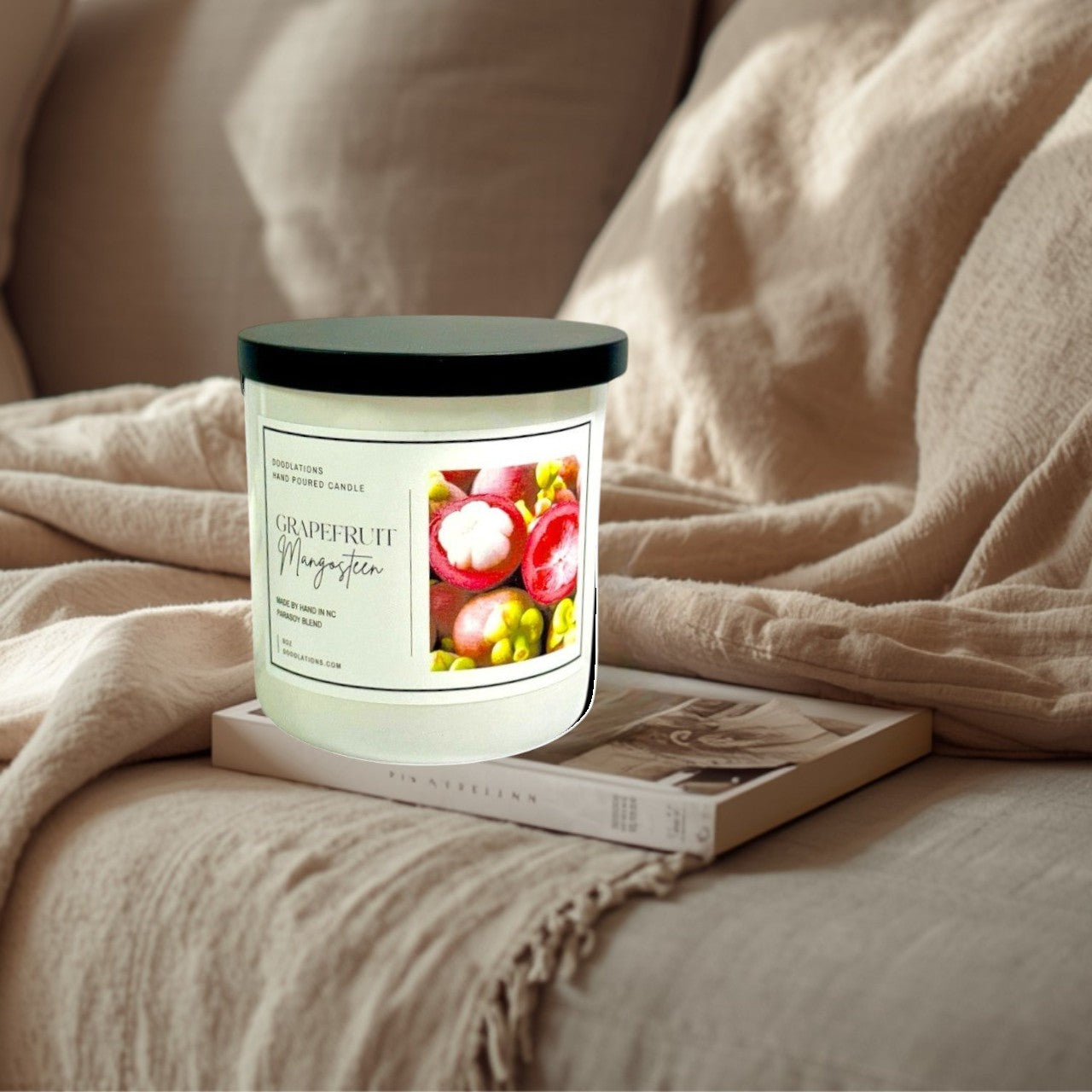 Doodlations Coffee Bar & Boutique Grapefruit & Mangosteen hand-poured candle in a white jar with a black lid. Features a label with fruit imagery.