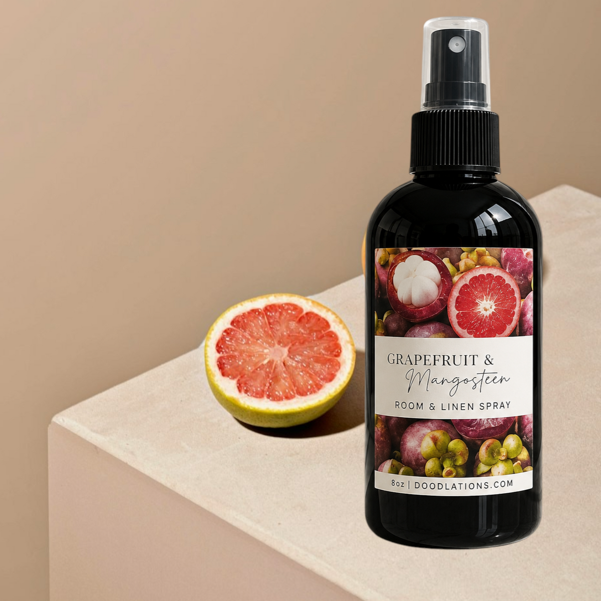 Doodlations Coffee Bar & Boutique Grapefruit & Mangosteen room and linen spray in a black bottle with citrus fruit