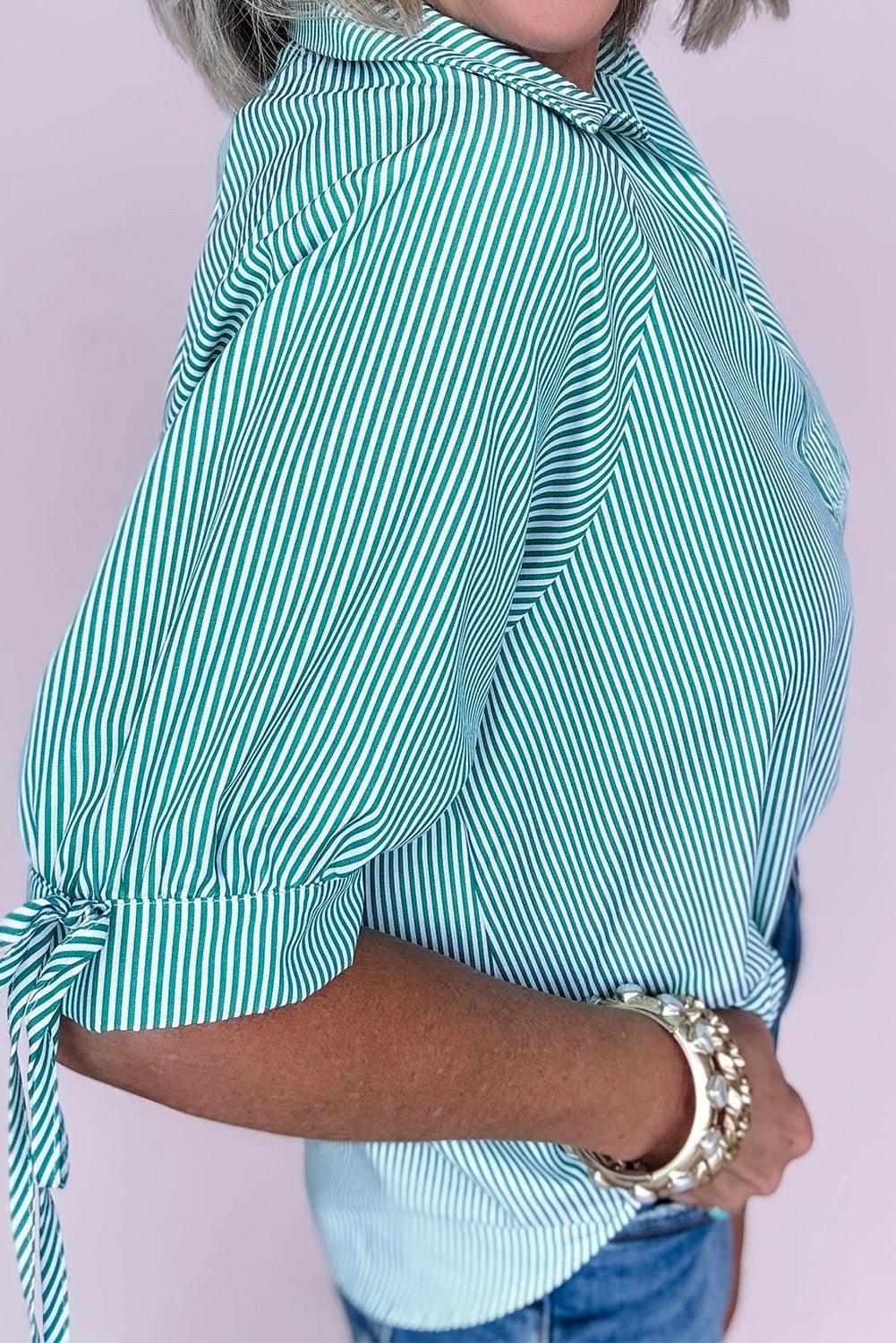 Doodlations Coffee Bar & Boutique green and white striped puff sleeve button-up shirt with tie cuffs.