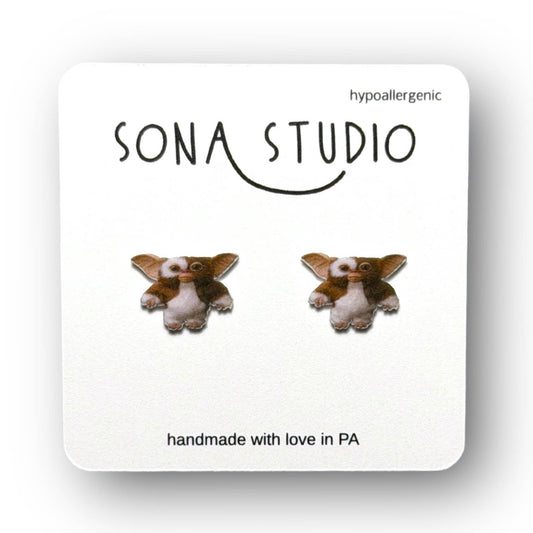 Doodlations Coffee Bar & Boutique Before Midnight earrings featuring cute brown and white Gremlin character studs.