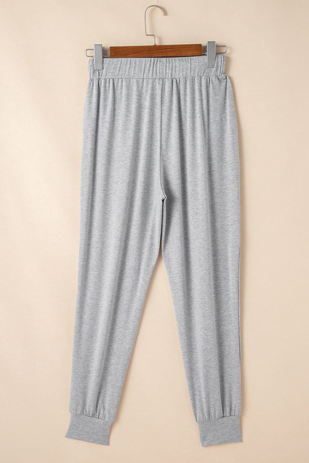 Doodlations Coffee Bar & Boutique grey lounge joggers with elastic waistband and cuffed ankles on a wooden hanger