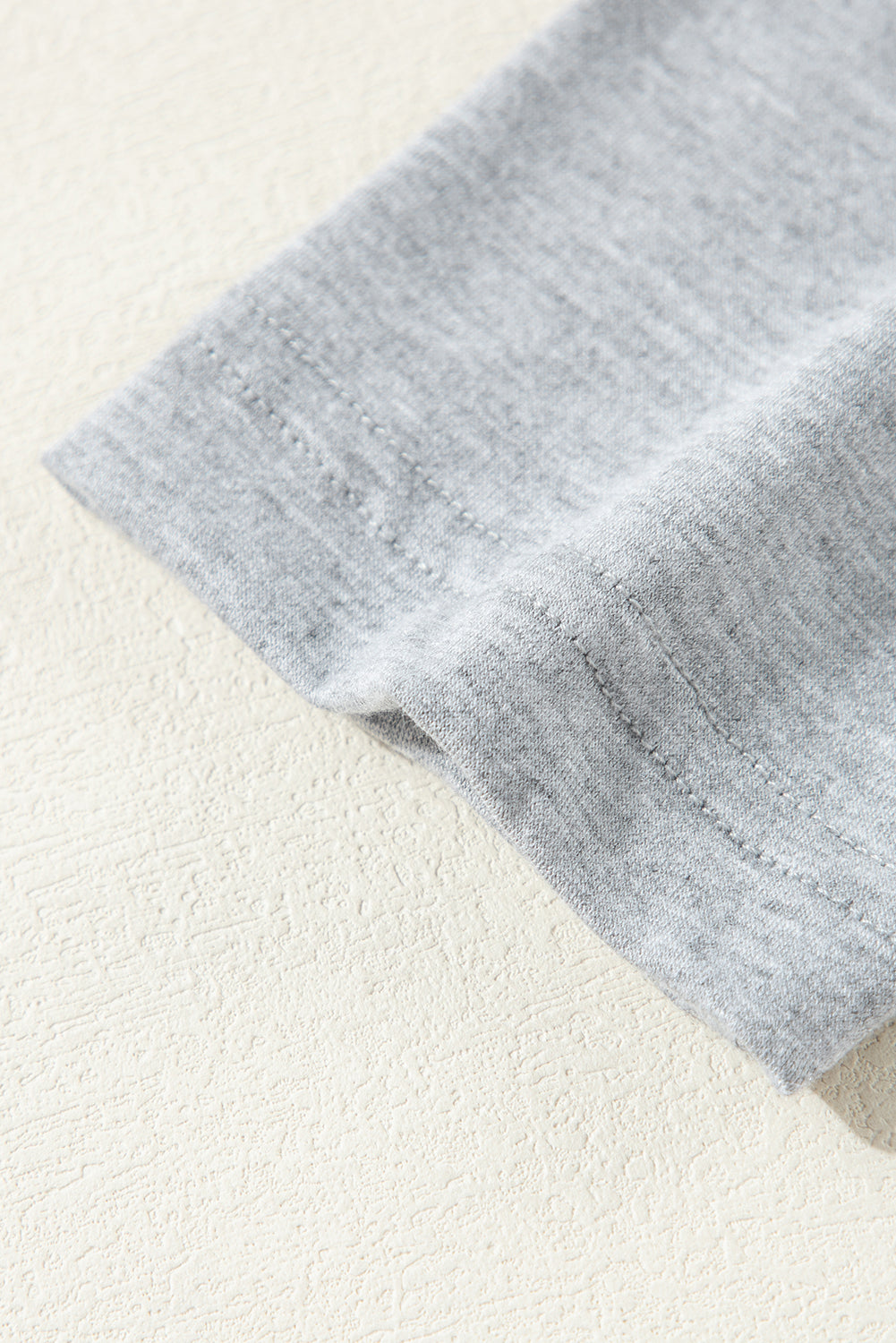 Close-up of soft grey fabric from a Doodlations Coffee Bar & Boutique loungewear set showing fine knit texture