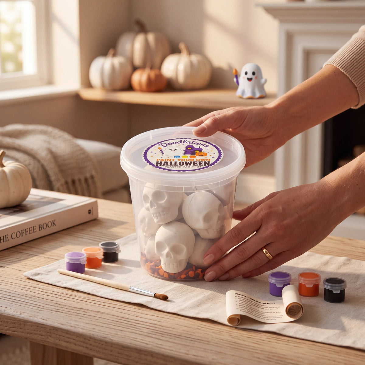 Doodlations Coffee Bar & Boutique Halloween plaster skull painting kit with paints, brushes, and instructions.