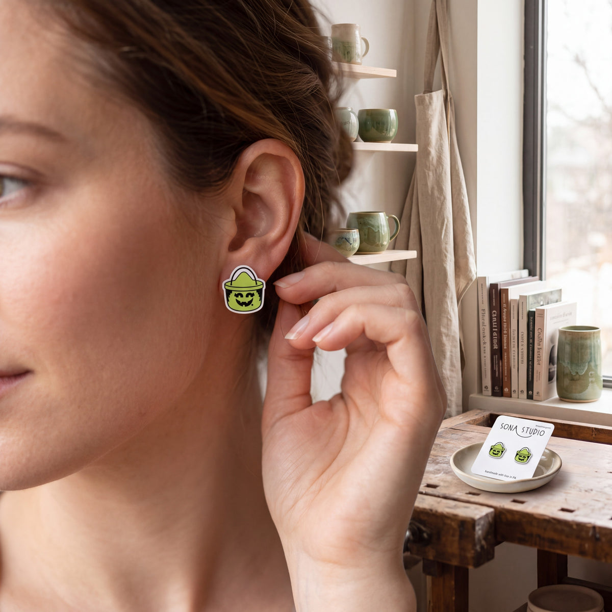 Doodlations Coffee Bar & Boutique retro Halloween witch bucket acrylic stud earrings worn by a woman