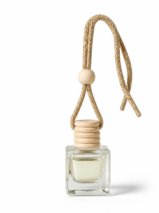 Doodlations Coffee Bar & Boutique hanging car diffuser in a clear glass bottle with a wooden cap and braided cord.