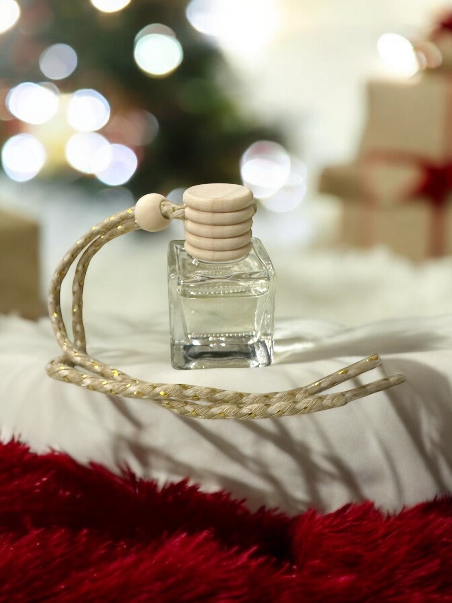 Doodlations Coffee Bar & Boutique hanging car diffuser in a clear glass bottle with a wooden cap and braided cord.
