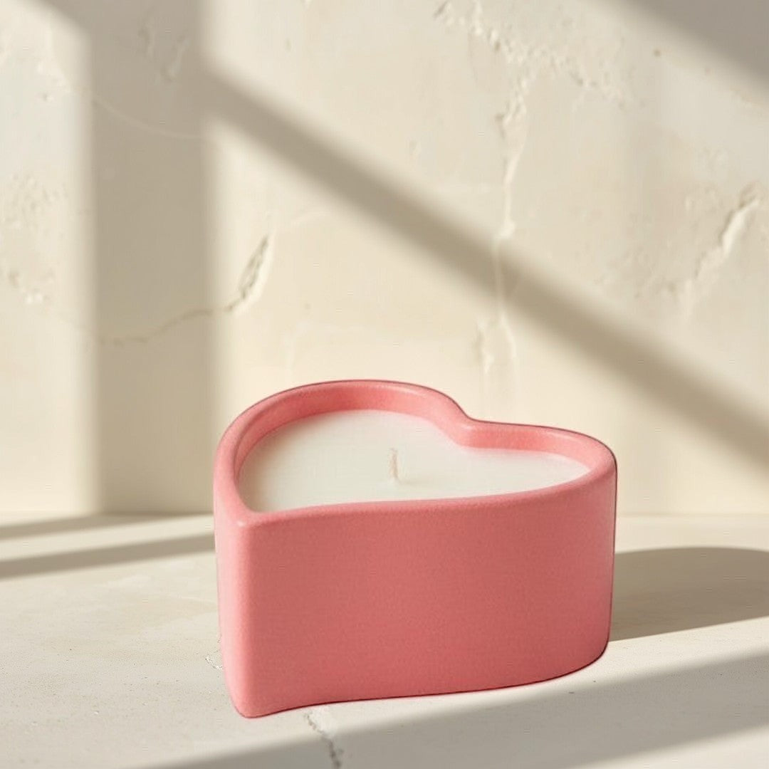 Doodlations Coffee Bar & Boutique coral pink heart-shaped concrete candle with white wax.