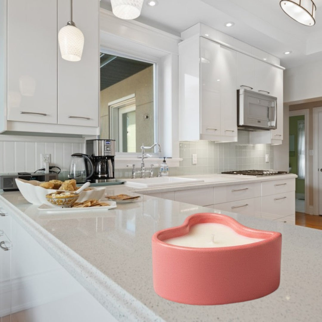 Doodlations Coffee Bar & Boutique coral pink heart-shaped concrete candle with a white wax fill and wick.