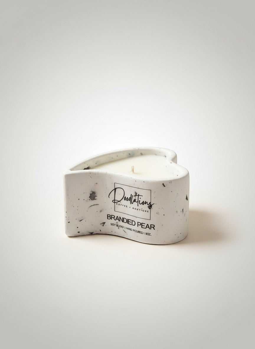 Doodlations Coffee Bar & Boutique heart-shaped concrete candle with white wax, labeled 'Branded Pear'.