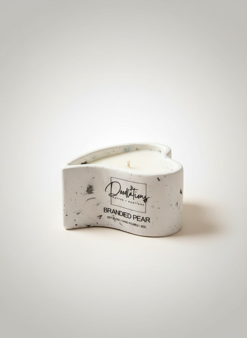 Doodlations Coffee Bar & Boutique heart-shaped concrete candle with white wax, labeled 'Branded Pear'.