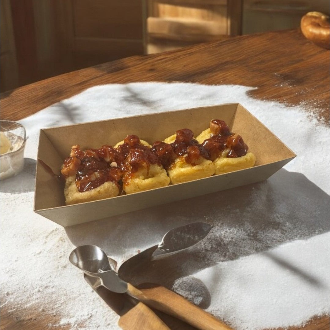 Doodlations Coffee Bar & Boutique Hot Apple Pies wax melts in a brown paper tray, dusted with powdered sugar.